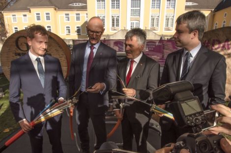 4 Männer halten zur feierlichen Eröffnung eine Glasfaserkabel in der Hand. Auf der linken Seite Sachsens Ministerpräsident Kretschmar.